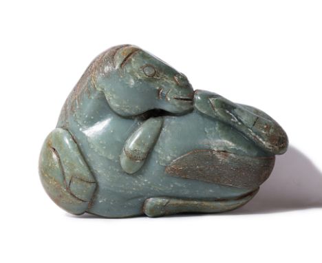 A LARGE JADE BOULDER CARVING OF A HORSE
Modelled as laying on it's back with raised fore and hind legs, incised facial featur