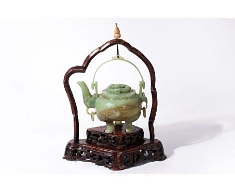 A JADE TRIPOD TEAPOT
Gobular teapot with chilong to cover, the feet decorated with foo lions, ring lugs to front and back, de