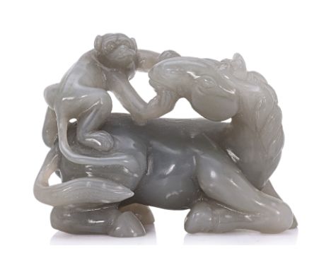 A CARVED JADE HORSE AND MONKEY GROUP The stone of a pale grey tone, the horse modelled lying with its head turned backwards, 