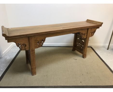 A Chinese elm altar table, the top with scroll ends above a cloud carved frieze on square supports with carved panels, 218 cm