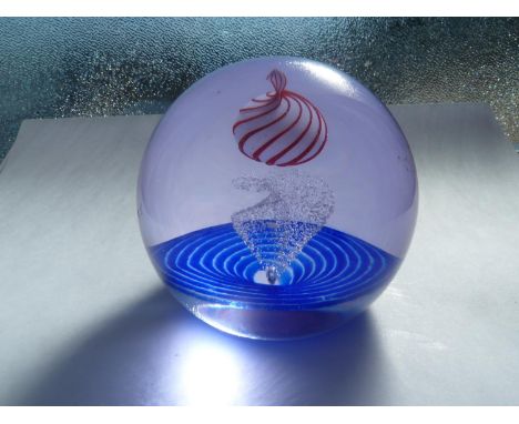 Caithness - Planet Peppermint - A glass paperweight, the white planet striped in red over a granular swirl on a blue spiral b