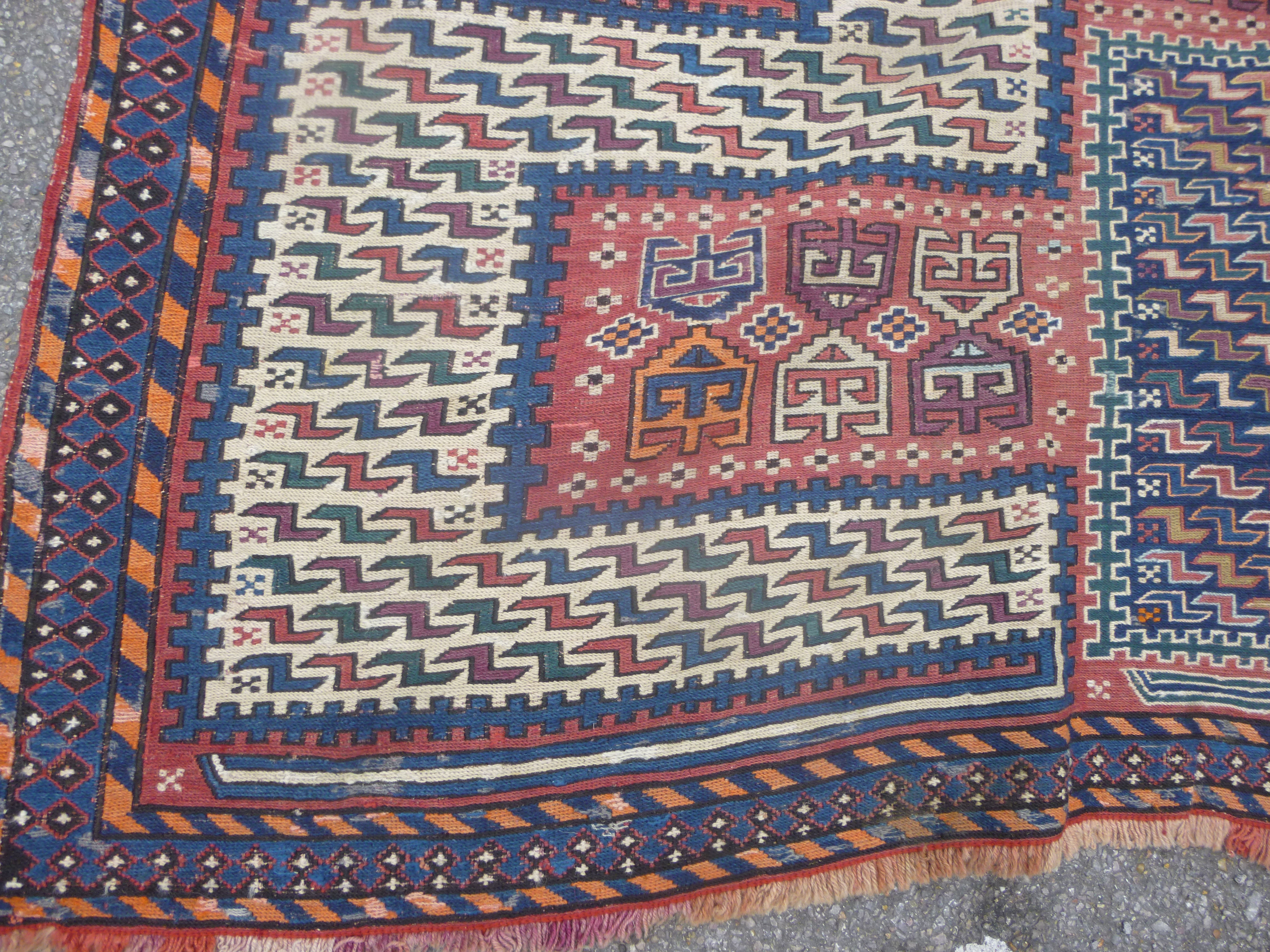 A Caucasian Sileh rug with a herringbone and gul pattern, on a red and ...