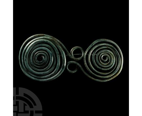 8th-7th century B.C. Comprising a pair of opposing wire coils decreasing in thickness from edge to centre, a figure-of-eight 