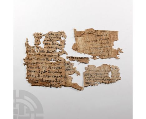 Circa 100 B.C. Fragments of a papyrus manuscript with text in Demotic script, remains of a painted grid or decorative figure.