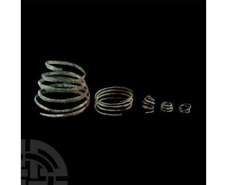 2nd-1st millennium B.C. Two coiled bracelets with D-section and round-section bodies; three differently sized coiled rings.  