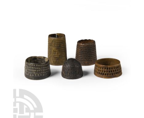 Circa 15th-17th century A.D. Comprising ring-type thimbles and a domed top thimble, four with dimples, one notched around the