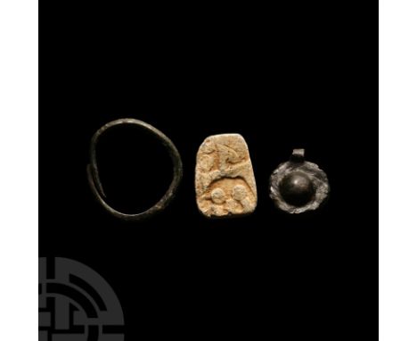 9th-11th century A.D. Comprising: a thumb ring with overlapping arms and lozenge cross-section; a lead trade weight for preci