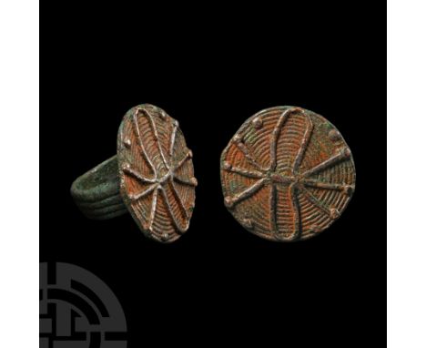 1st millennium B.C. With four-banded hoop and large circular bezel also made from coiled wire, insect(?) motif applied to the
