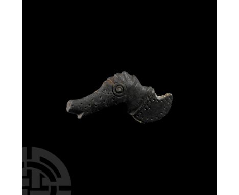 8th-10th century A.D. Elliptical in cross-section with a ring-and-dot eye to each face, ridged coxcomb and upturned muzzle; s
