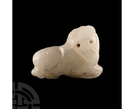 Circa 3rd millennium B.C. Carved figure of a recumbent bull with headed turned, drilled eyes, legs folded beneath the body; d
