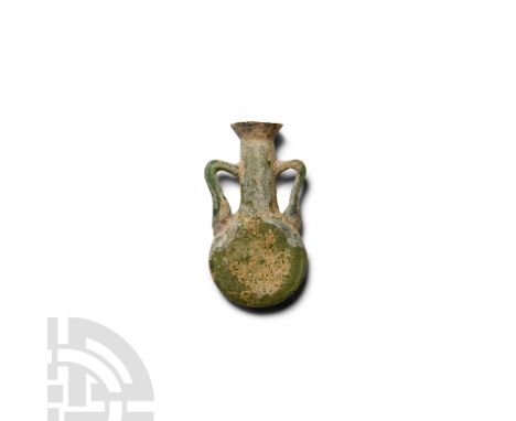 1st century A.D. Amphoriskos with flat disc-shaped body, tubular neck with flared rim, two lateral knee-shaped handles to the