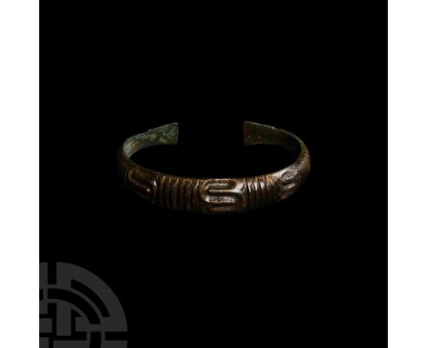9th-11th century A.D. Of penannular form, convex outer face displaying geometric compositions including vertical grooves, sna
