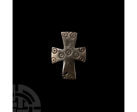 Circa 6th-7th century A.D. Shaped as an equal-armed cross, surface decorated with pellet-in-circles, catch and fastening pin 
