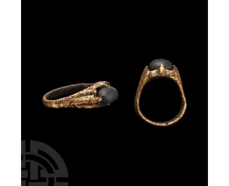 12th-13th century A.D. With bag-shaped hoop, raised lateral straps developing to the claw setting, inset blue glass cabochon.