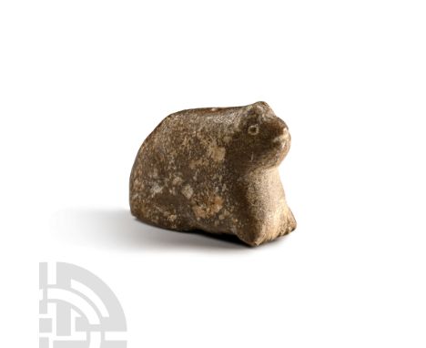 Circa 3rd millennium B.C. Carved figure of a crouching cat with pricked ears; drilled at the shoulder for suspension. Cf. A P