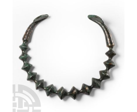 Circa 3rd-2nd century B.C. The penannular body formed with recurved terminals and graduated biconical bulbs.   366 grams, 16 