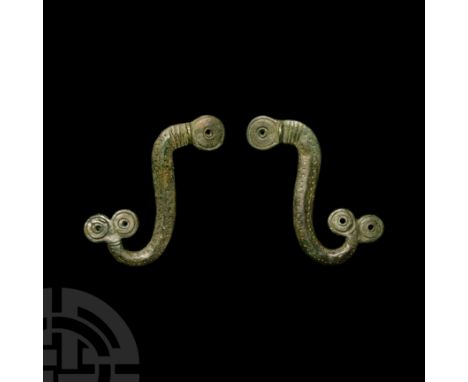 Circa 1st century A.D. Each a scrolled bar formed as a serpent or other animal with stylised geometric detailing; attachment 