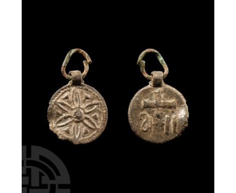 9th-12th century A.D. The discoid body displaying a cross to one face and a stylised flowerhead to the other; suspension loop