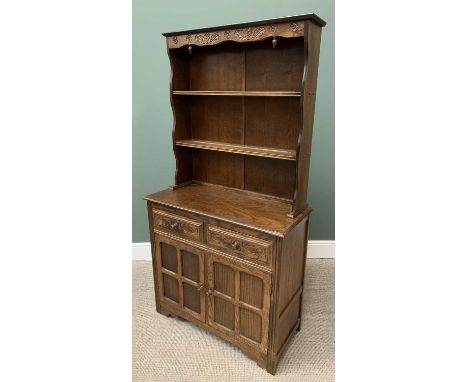 REPRODUCTION OAK DRESSER having carved detail to the two shelf rack over a base section with two frieze drawers and twin cupb