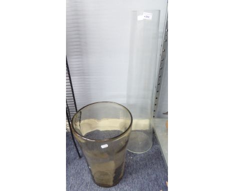 A LARGE PLAIN GLASS TAPERED CYLINDRICAL  VASE, 32" HIGH AND A LARGE AND HEAVY BUCKET SHAPED GLASS VASE, 16" HIGH, 16 1/2" DIA