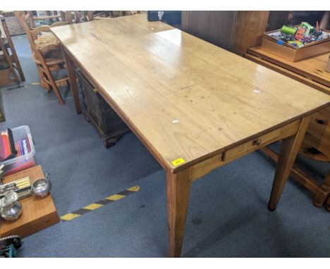 A late 19th/early 20th century French fruitwood plank constructed dining table, 77cm h x 180cm w, together with six ladder ba