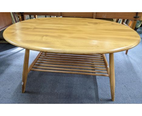 A vintage Ercol blonde elm and beech oval topped coffee table with magazine rack below, 44cm h x 99.5cm wLocation: 