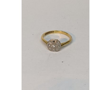 An 18ct yellow gold and platinum diamond set ring, the octagonal plaque top in daisy style set with five small brilliant cut 