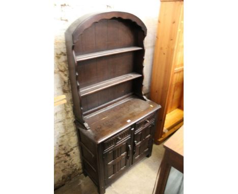 A dark elm dresser of Ercol design, the open rack with arched top, 92 cm wide x 42 cm deep x 175 cm high 