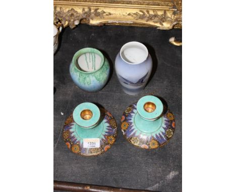 A pair of Crown Devon Fielding's squat pillar candlesticks of Art Deco design, decorated in colours with flowers on a pale gr