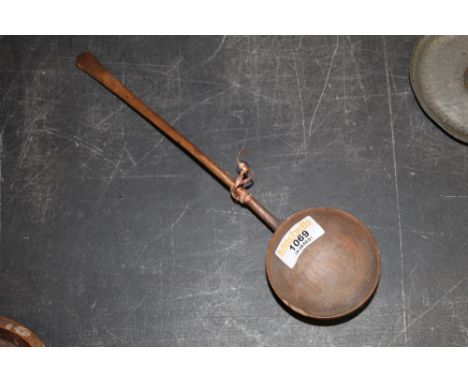 A 19th century carved wood ladle with circular bowl, 28 cm long, chip to rim. 