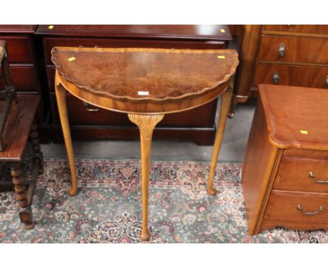 A 1940's figured walnut demi lune console table with pie crust rim, 74 cm wide x 39 cm deep x 74 cm high and a laminate two d