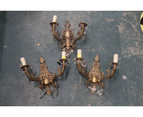 Three wall light fittings in the form of two branch candelabras with lustre drops 