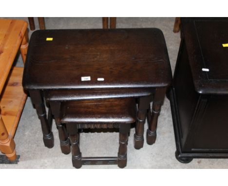 A nest of three dark elm rectangular occasional tables of Ercol design, the largest 60 cm wide x 38 cm deep x 47 cm high 