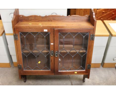 An oak wall mounted cabinet, fitted single shelf enclosed by a pair of leaded glazed door, 87 cm wide x 23 cm deep x 113 cm h