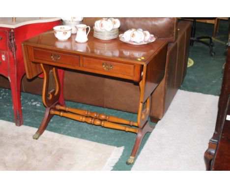 A modern sofa table with two drawers, lyre shaped sides and hairy paw feet