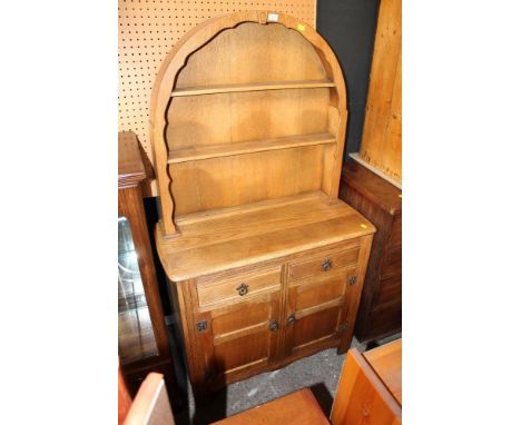 A light oak dresser of Ercol design, the open rack with arched top, 92 cm wide x 42 cm deep x 170 cm high