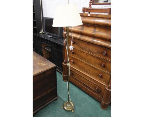 A brass lamp standard with cream shade
