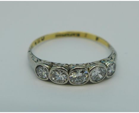 An 18ct gold, platinum set five stone diamond ring, approximately 0.65 carat diamond weight, 2.7g, R