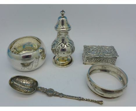 A silver pepper, a modern silver snuff box, two silver napkin rings and a silver spoon, 66g