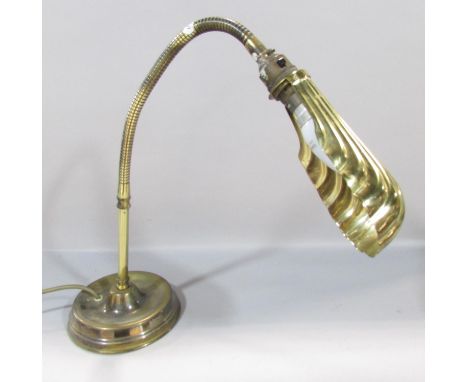 An Edwardian brass reading lamp with a shell shade on a flexible arm. 