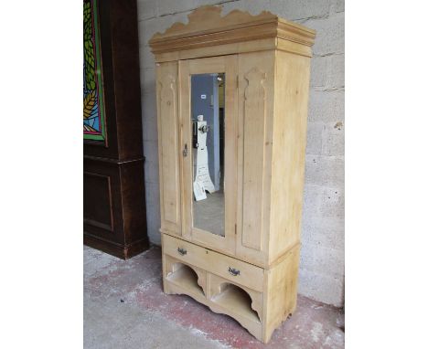 An Edwardian striped pine wardrobe enclosed by a three quarter length mirror panelled door, flanked by applied panels over a 