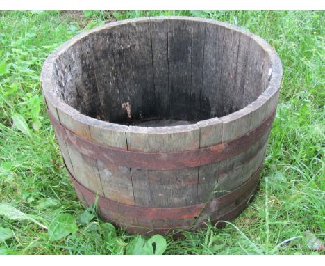 A weathered coopered oak and steel banded half barrel planter, 39 cm high x 64 cm diameter, together with a moulded plastic b