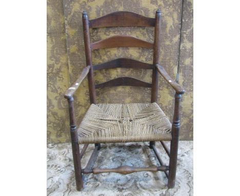 A 19th century rush-seated ladder-back elbow chair 