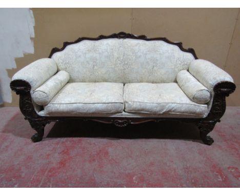 A Regency drawing room sofa with showwood frame depicting shells, scrolls and other detail, raised on lion's paw feet, with r
