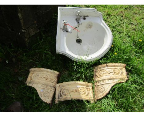 A Victorian ceramic corner washbasin and wall mounted cast iron bracket in three sections with raised relief floral detail, (