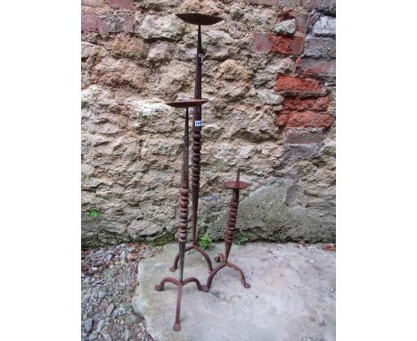 Three old weathered iron pricket candlestands (same design but varying height) with faceted and bobbin stems, the tallest exa