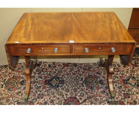 A Georgian mahogany sofa table of usual form incorporating two real and two dummy drawers raised on swept supports with strin