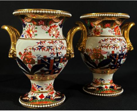 A pair of early 19th century Spode vases with applied loop handles and mask borders, with hand painted chinoiserie detail set