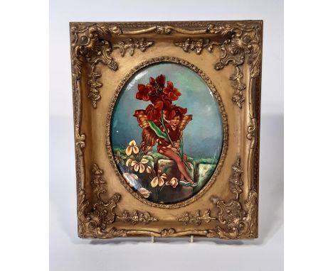 A ceramic plaque, decorated with a flower nymph, in a moulded gilt frame 