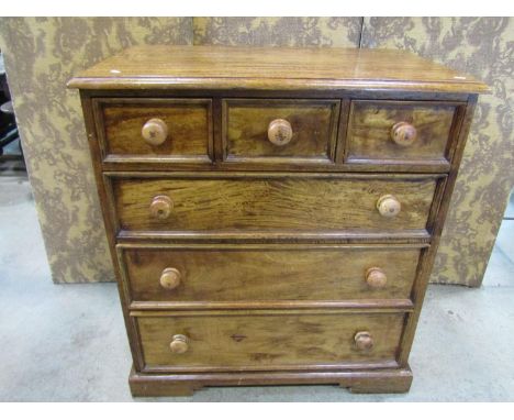 A large and heavy satin hardwood chest of three short and three long drawers, with turned handles, raised on bracket supports